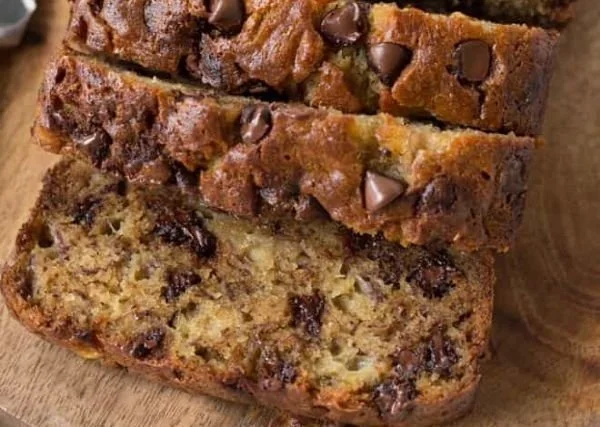 Sliced chocolate chip banana bread on a wooden cutting board