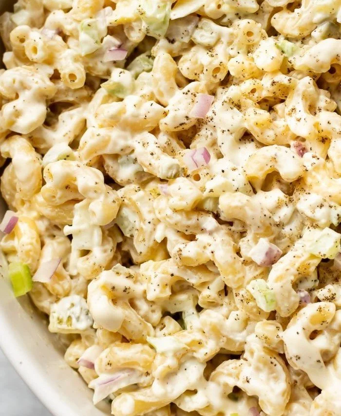 Creamy macaroni salad served in a bowl with fresh vegetables
