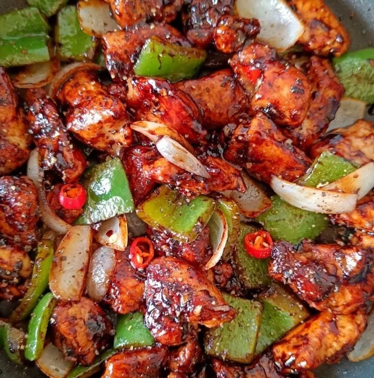 A plate of easy black pepper chicken garnished with vegetables