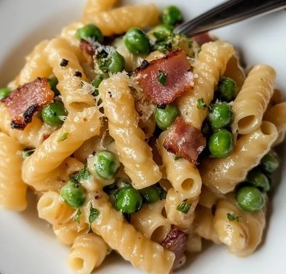 Creamy pasta dish with sweet peas and crispy pancetta served in a bowl