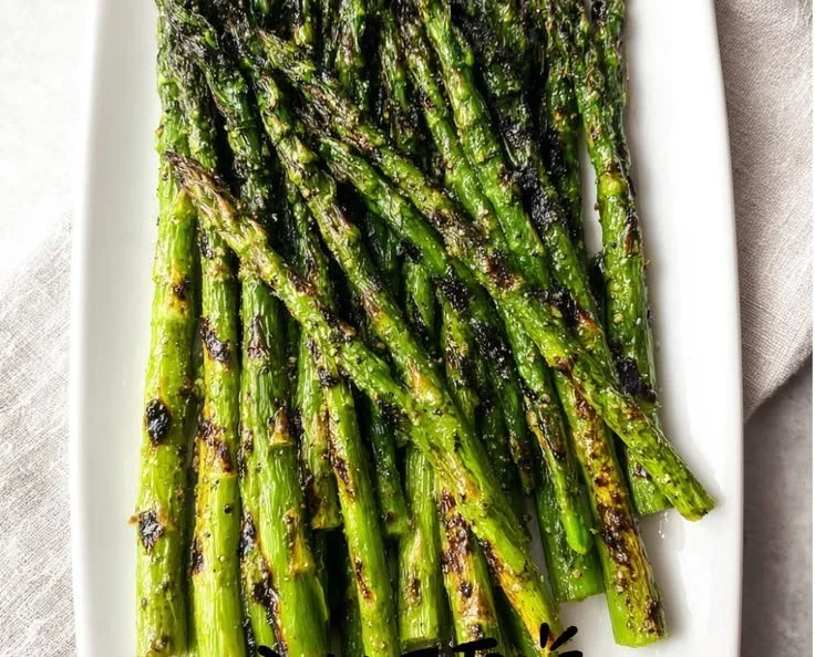 Crispy asparagus cooked on a Blackstone griddle, ready to serve.