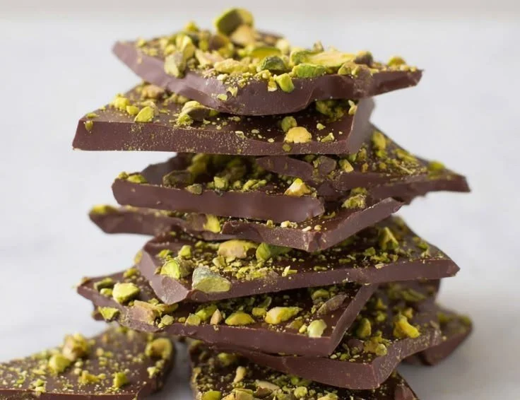 Delicious Dubai chocolate bark with nuts and sprinkles on a decorative plate.