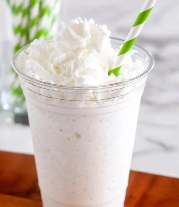 Homemade vanilla bean frappuccino in a glass with whipped cream on top