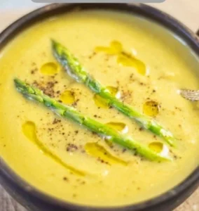 Bowl of creamy Instant Pot asparagus soup garnished with fresh herbs