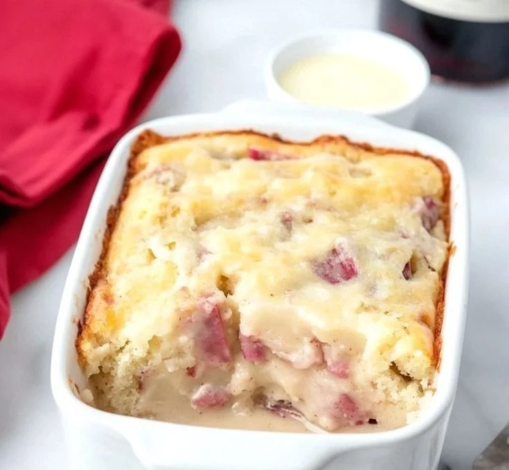 Moist rhubarb cake topped with delicious butter sauce on a plate