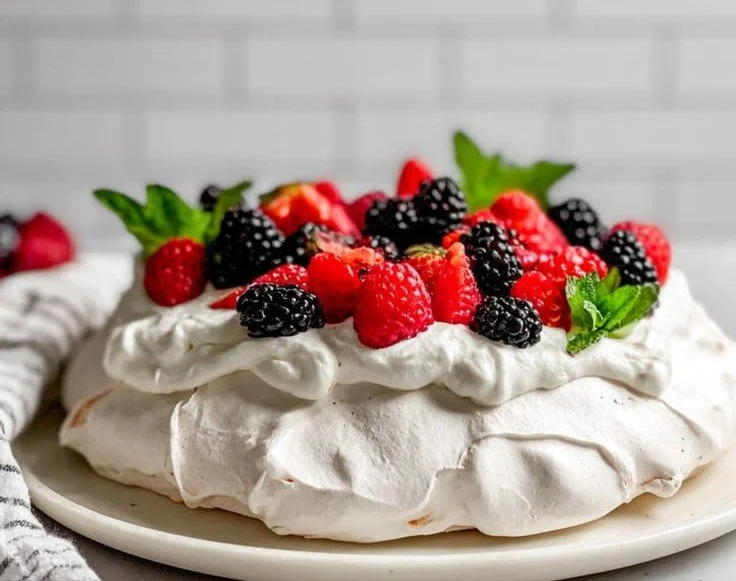 Delicious Pavlova topped with fresh berries for a delightful dessert.