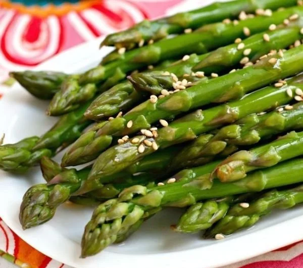 Quick sesame marinated asparagus dish with sesame seeds and vibrant green stalks.