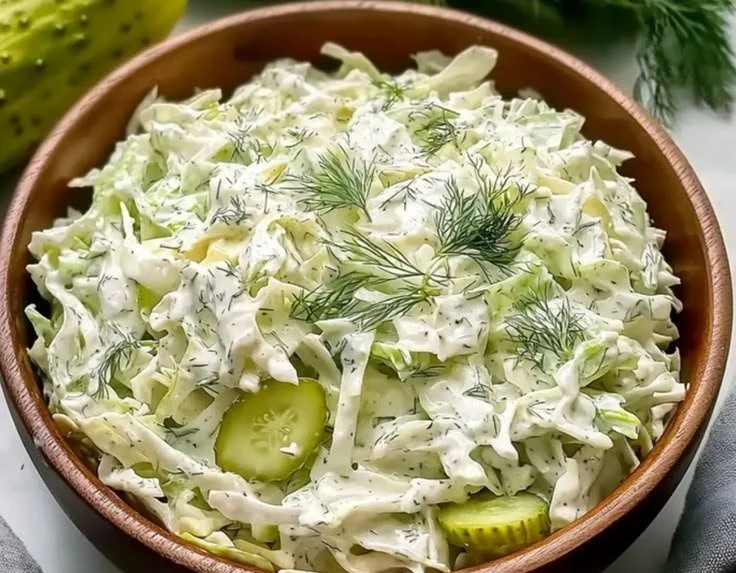 Creamy dill coleslaw dressing served in a bowl with fresh ingredients.