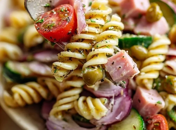 Bowl of easy ham pasta salad with colorful vegetables and dressing.
