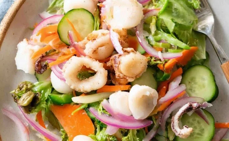 Delicious garden salad topped with crispy calamari and fresh vegetables