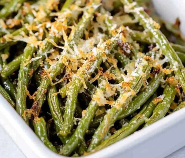 Plate of Garlic Parmesan Green Beans garnished with parmesan cheese and garlic