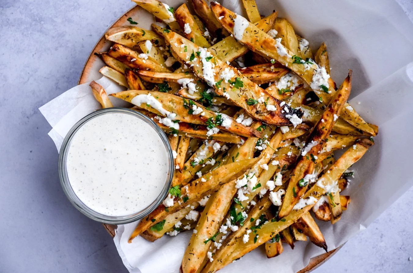 Delicious loaded Greek fries topped with feta, olives, and tzatziki sauce