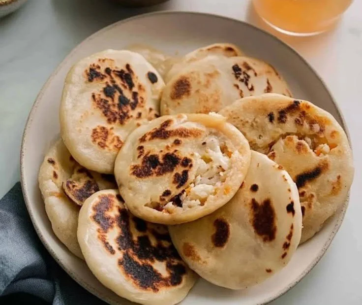 Delicious pupusas served with tangy pickled cabbage on a rustic plate