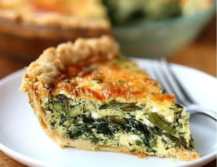 Freshly baked asparagus quiche with a golden crust and vibrant asparagus topping.