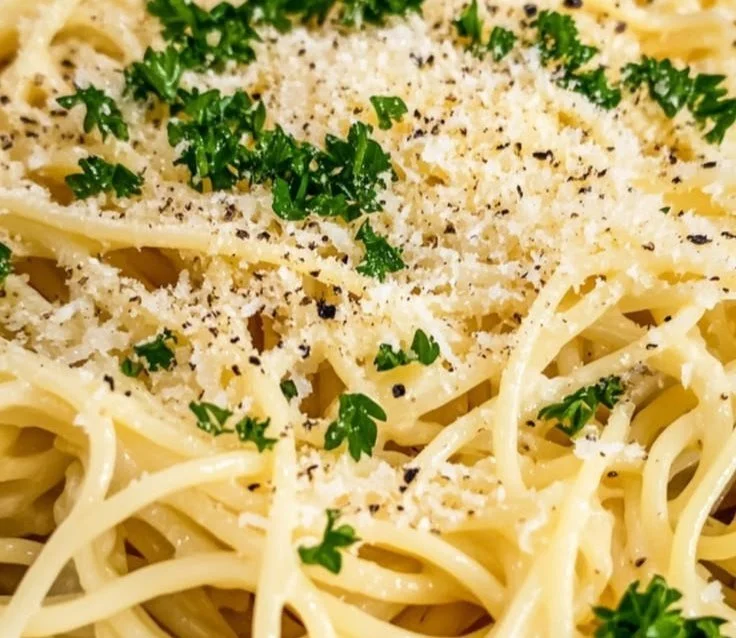 A plate of easy Parmesan noodles garnished with parsley and grated cheese
