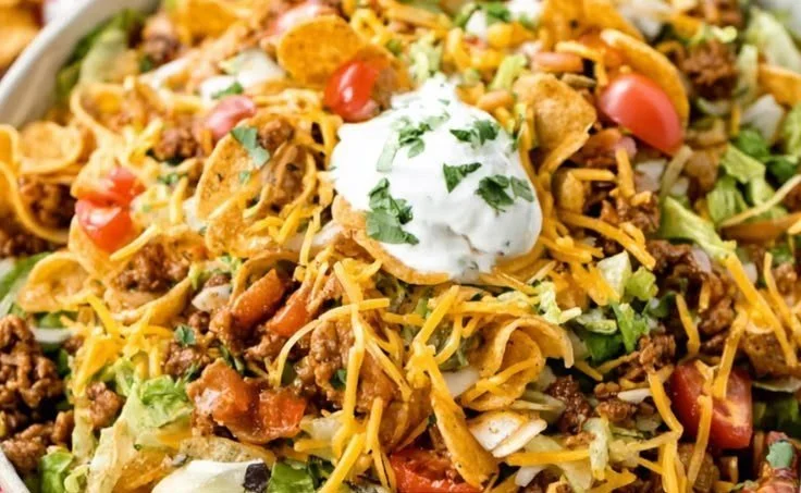 Colorful Frito Taco Salad with toppings and Fritos displayed in a bowl