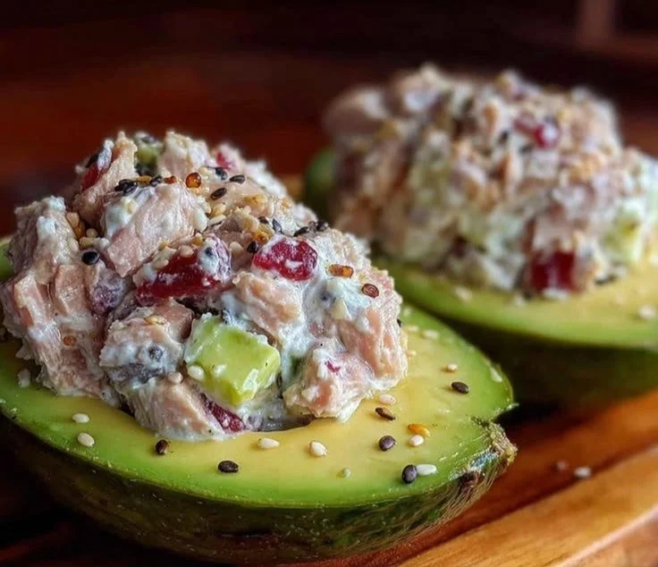 High-protein tuna stuffed avocado on a plate garnished with herbs