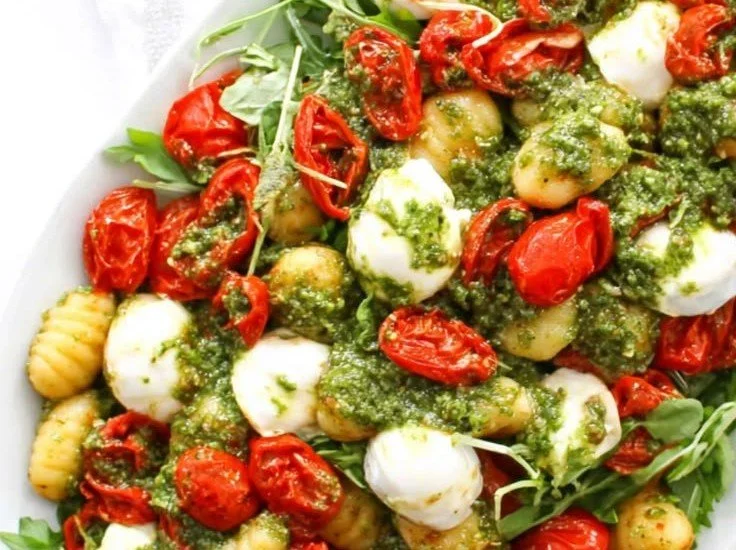 Roasted gnocchi salad with pesto sauce and mozzarella cheese on a plate