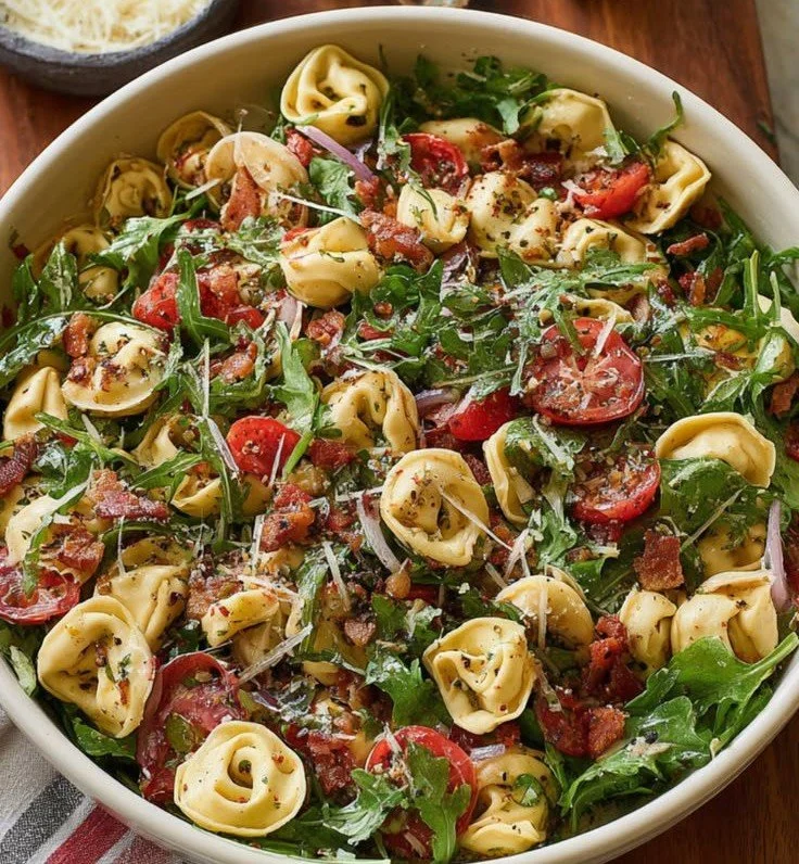 Colorful tortellini pasta salad with fresh vegetables and dressing.