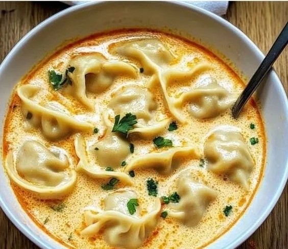 Bowl of creamy Thai Dumpling Soup garnished with herbs and spices