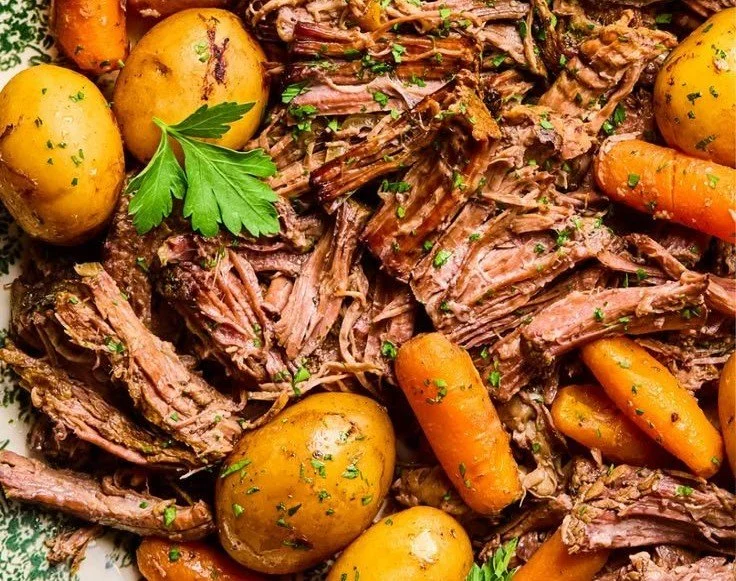 Delicious crock pot chuck roast served with vegetables and gravy.