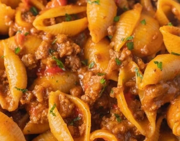 Bowl of high protein taco pasta topped with cheese and cilantro