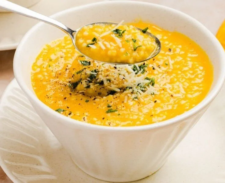 A steaming bowl of Italian Penicillin Soup with herbs and vegetables.