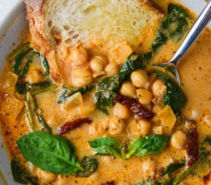 A bowl of Tuscan Chickpea Soup garnished with herbs and vegetables