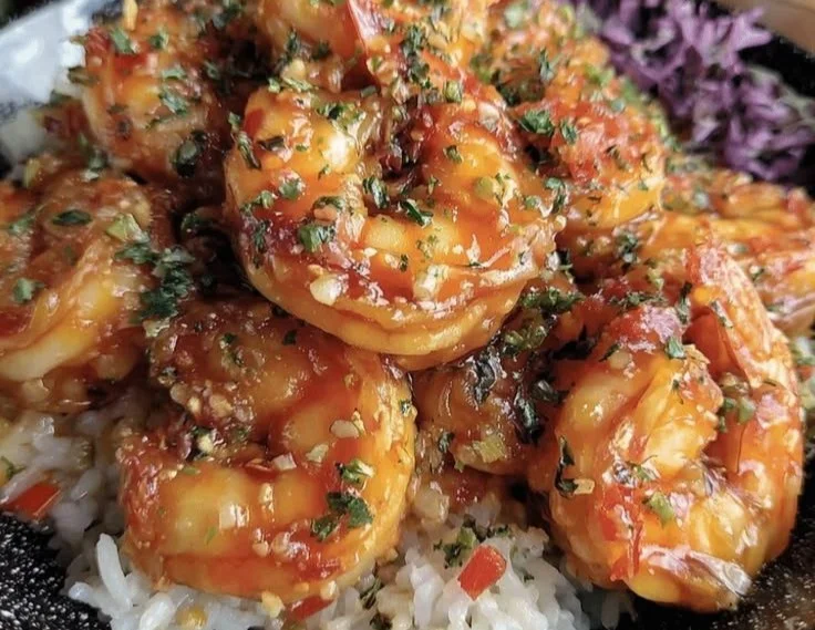 Plate of Garlic Butter Shrimp served with rice and garnished with herbs
