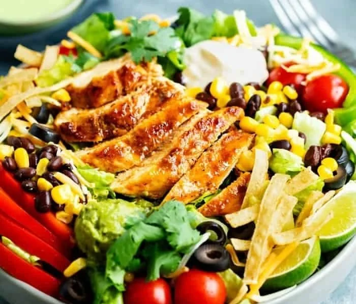 Colorful Southwest Salad with fresh vegetables, beans, and dressing in a bowl