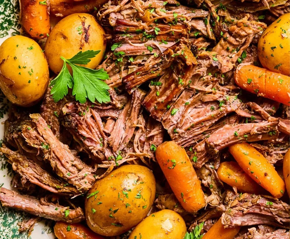 Juicy crockpot pot roast ready to serve with vegetables on a plate.