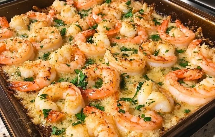 Lemon garlic baked shrimp on a plate, garnished with herbs.