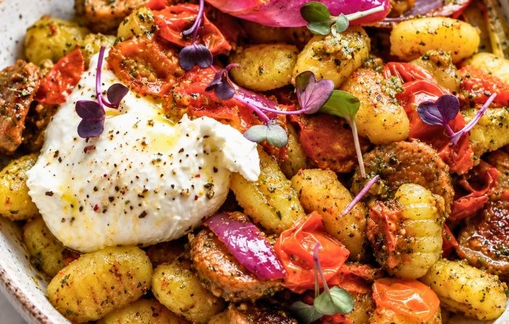 Delicious sheet pan pesto gnocchi with sausage and burrata on a baking tray